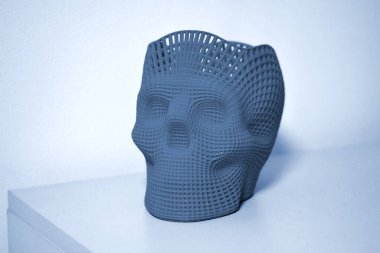 3D yazıcıda mavi gri renkli plastik ile basılmış kafatası.