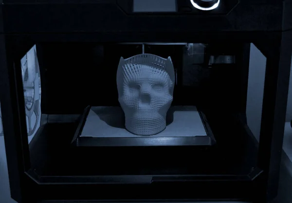 Skull printed with plastic of blue gray color on 3d printer.