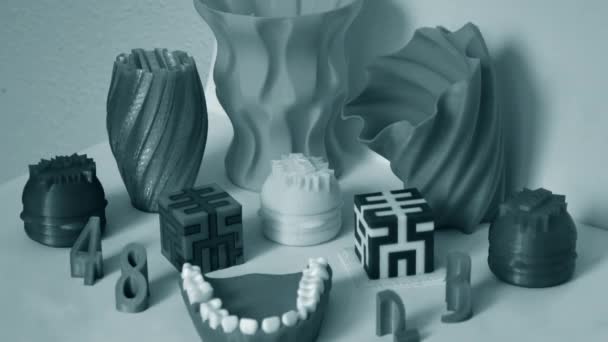 3D nyomtató által nyomtatott modellek. 3d nyomtatóra nyomtatott tárgyak a táblán — Stock videók