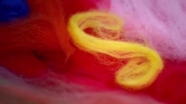 Pembe yün ve kırmızı arka planda sarı yün spiral