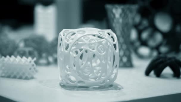 Abstrakcyjny obiekt koloru niebieskiego wydrukowany na drukarce 3D na białym stole — Wideo stockowe