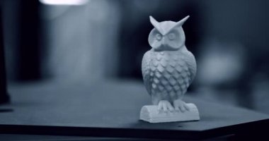 3D yazıcı tarafından basılan mavi baykuş nesnesi bulanık koyu arkaplan üzerinde duruyor