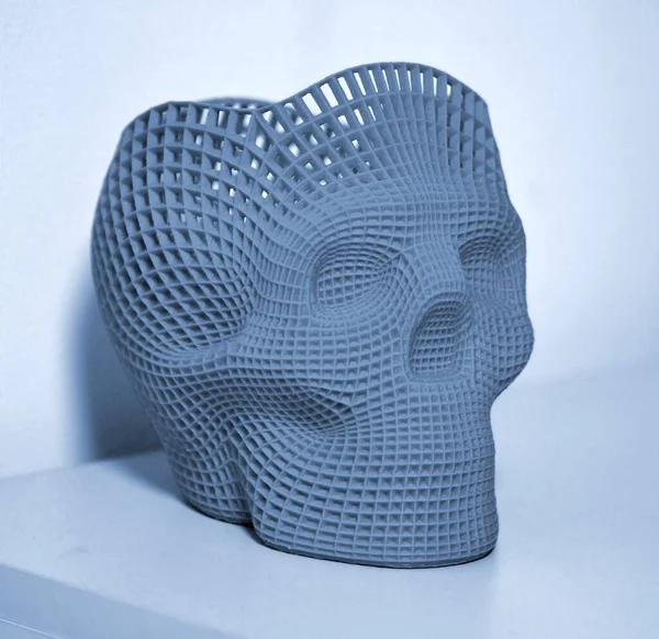 Skull printed with plastic of blue gray color on a 3d printer.