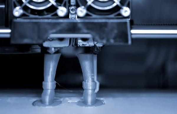 3D printer prints the form of molten plastic green.