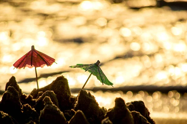 모래 위에서 칵테일을 위한 종이로 만든 두 개의 작은 해변 우산 — 스톡 사진