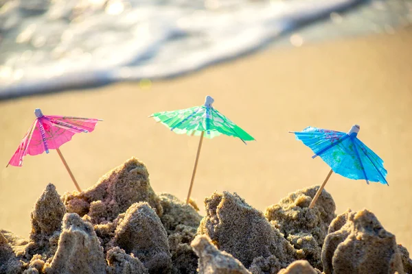 모래 속에서 칵테일 판매대용 종 이 로만든 세 개의 작은 해변 우산 — 스톡 사진