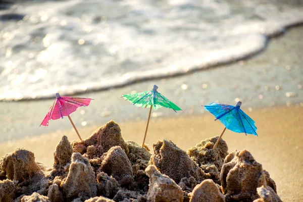 모래 속에서 칵테일 판매대용 종 이 로만든 세 개의 작은 해변 우산 — 스톡 사진