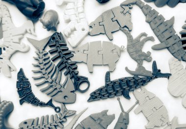 3d yazıcıya basılmış pek çok parlak renkli nesne düz yüzeyde yatıyor