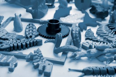 3d yazıcıya basılmış pek çok parlak renkli nesne düz yüzeyde yatıyor