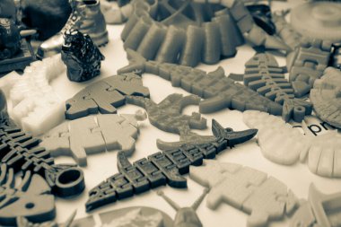 3d yazıcıya basılmış pek çok parlak renkli nesne düz yüzeyde yatıyor