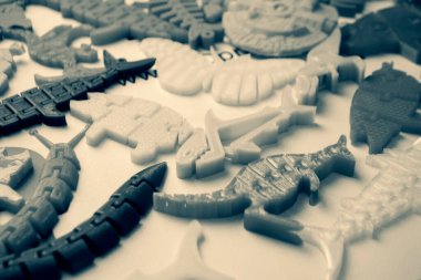 3d yazıcıya basılmış pek çok parlak renkli nesne düz yüzeyde yatıyor