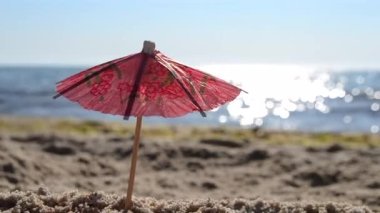 Güneşli bir yaz gününde, kumsalda kumsalda kağıt kokteyl şemsiyeleri.