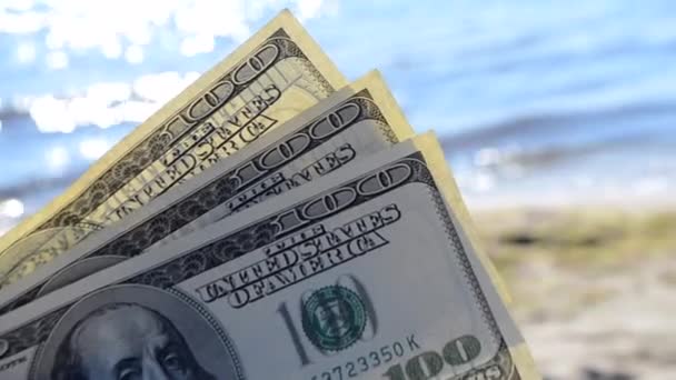 Dollar bills on background of sea on sunny day close-up. — Stock Video