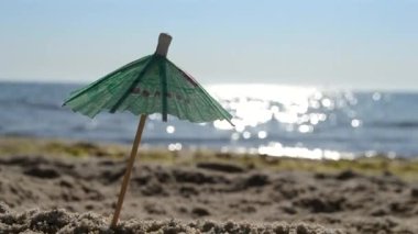 Güneşli bir yaz gününde, kumsalda kumsalda kağıt kokteyl şemsiyeleri.