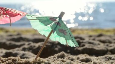 Güneşli bir yaz gününde, kumsalda kumsalda kağıt kokteyl şemsiyeleri.