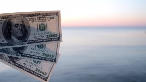 Tři sta dolarů bankovky na pozadí mořského povrchu. 100 dolarů v hotovosti — Stock video