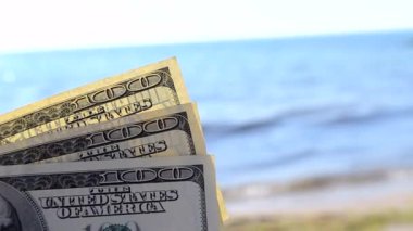 Güneşli bir günde arka planda dolar banknotları.