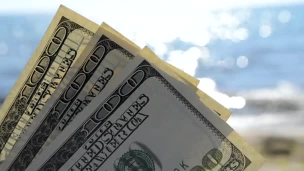 Dollar rekeningen op de achtergrond van de zee op zonnige dag close-up. — Stockvideo