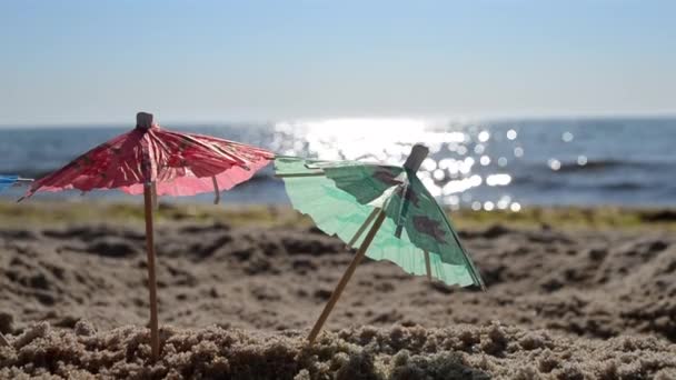夏日明媚的近照，海滨沙滩上的纸制鸡尾酒雨伞 — 图库视频影像
