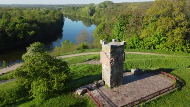 Légi drón kilátás repülés felett tisztás, világos zöld fű és kő régi torony — Stock videók