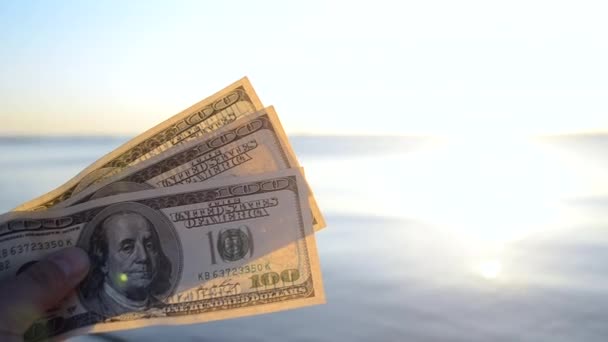 Τριακόσια δολάρια σε φόντο της επιφάνειας της θάλασσας. 100 δολάρια μετρητά — Αρχείο Βίντεο