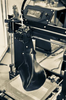 3D yazıcı siyah vazo gibi yakın plan bir model yazdırıyor.