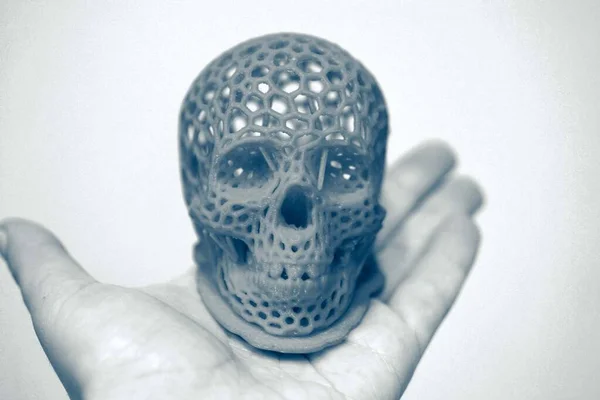 Skull printed with plastic of red color on a 3d printer.