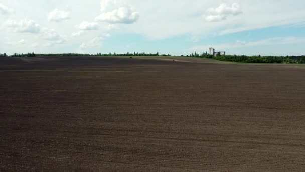 Drohnenflug über riesigem gepflügtem Feld und blauem Himmel. — Stockvideo