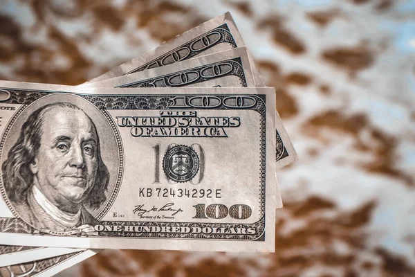 Girl holding money bill of 300 dollars on background of sea ocean