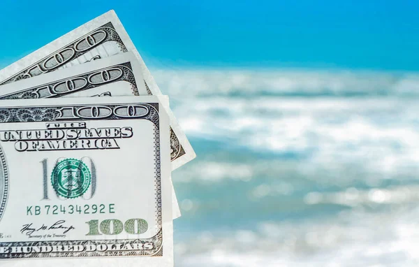 Meisje met geld rekening van 300 dollar op de achtergrond van de zee oceaan — Stockfoto