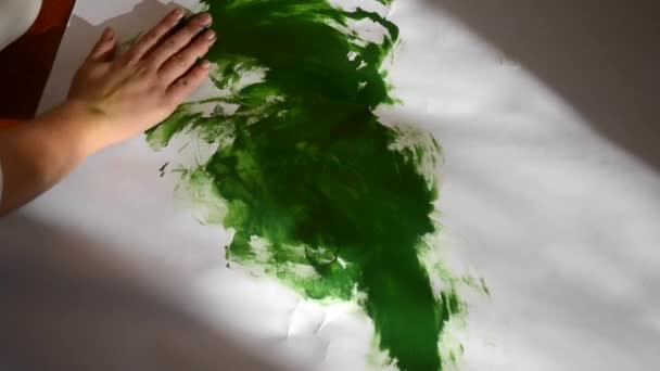 Girl smears paint on paper — Stock Video