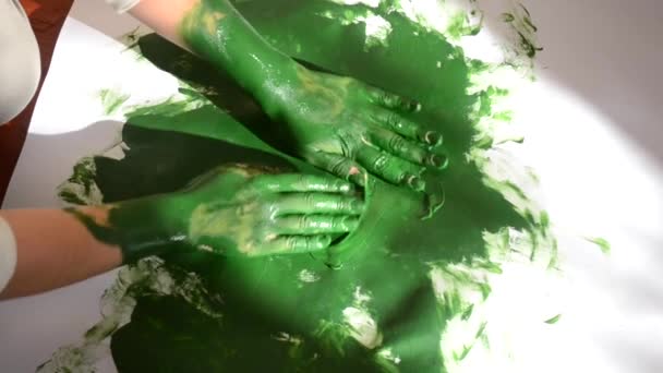 Donna spalma disegna vernice verde su una superficie bianca. — Video Stock