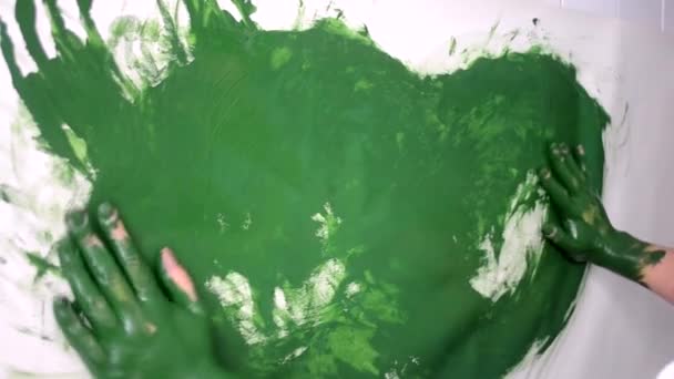 Mulher desenha uma tinta verde mancha suas mãos manchadas — Vídeo de Stock