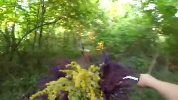 Mädchen fährt Fahrrad mit Blumenstrauß vor dem Rad — Stockvideo