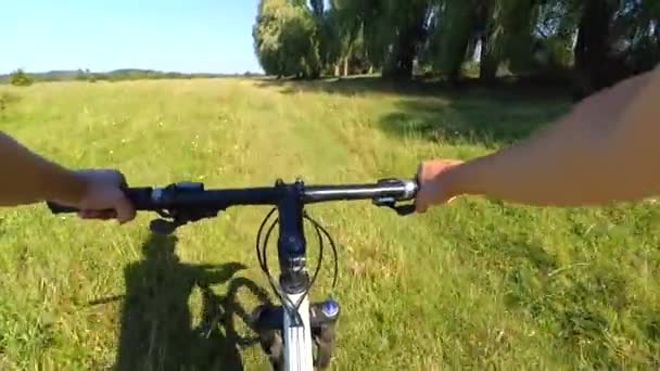 Человек на велосипеде в поле на зеленой траве — стоковое видео