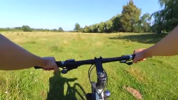 Muž na kole v poli na zelené trávě — Stock video