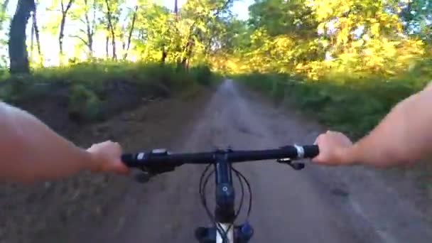 Person riding a cycle on a wide dirt road at dawn sunset — Stock Video