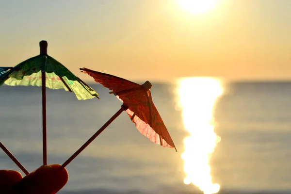 Az ember kezében három tengerparti koktél kis papír esernyő — Stock Fotó