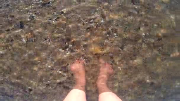 A girl stands barefoot in clean transparent water — Stok video