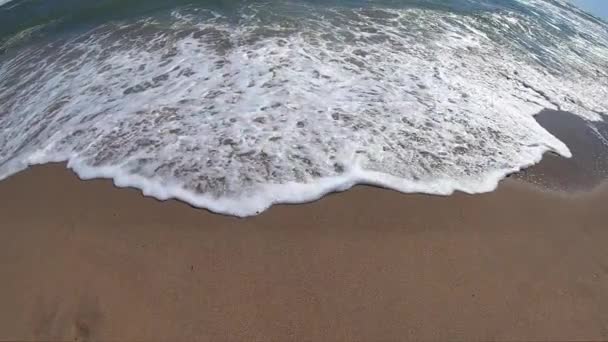 Ola de mar con rollos de espuma blanca sobre la orilla arenosa de la playa. Vista superior. — Vídeo de stock