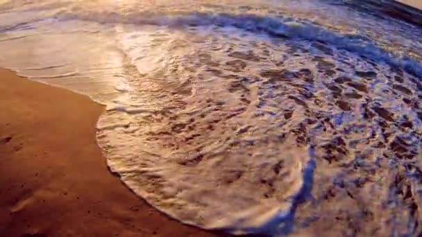 Mořská vlna s bílou pěnou se valí přes písečný břeh pláže. Horní pohled. — Stock video