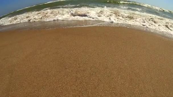 Onda marina con schiuma bianca rotola sulla riva sabbiosa della spiaggia. Vista dall'alto. — Video Stock