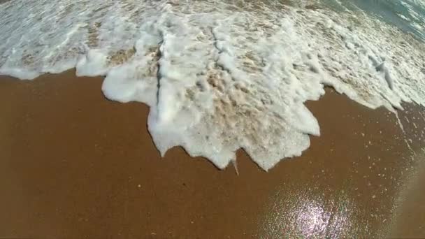 Kumsalın kumlu sahilinde beyaz köpüklü deniz dalgaları. Üst görünüm. — Stok video