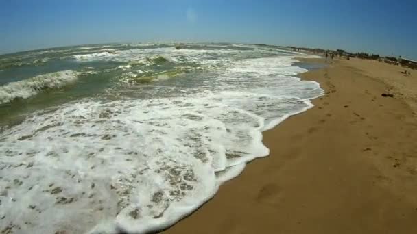 Vague de mer avec des rouleaux de mousse blanche sur le rivage sablonneux de la plage. Vue du dessus. — Video
