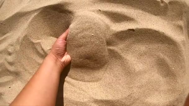 Chica scoops puñado de arena en su palma dispersa arena a través de los dedos — Vídeos de Stock