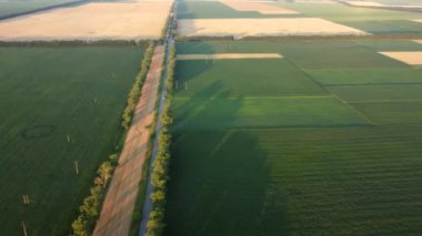Hava aracı şafak vakti farklı tarlalar arasında uçuyor..