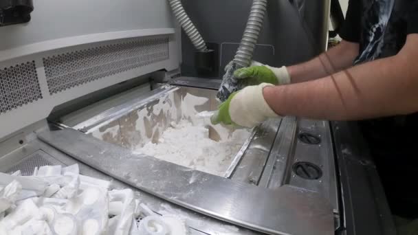 Ο άνθρωπος καθαρίζει τις λεπτομέρειες τυπωμένες σε βιομηχανικό 3D εκτυπωτή από λευκή πλαστική σκόνη — Αρχείο Βίντεο