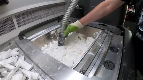 Homem limpa detalhes impressos em uma impressora 3D industrial de pó de plástico branco — Vídeo de Stock