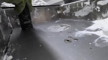 İnsan, endüstriyel 3D yazıcıda beyaz plastik tozundan basılan detayları temizler.