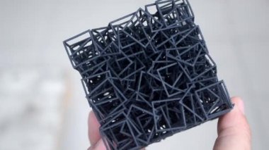 3D yazıcıya basılan el modelini tutan adam..